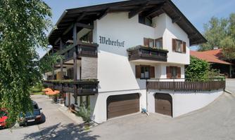 A charming building named "Weberhof" on the facade. It has several balconies and an inviting environment.