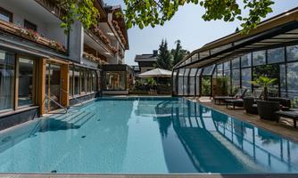 A beautiful pool in a modern building with large windows.  
Surrounded by seating and a relaxed atmosphere.