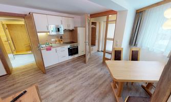 A modern kitchen with a dining area and windows overlooking the light. The space features bright woods and an inviting atmosphere.