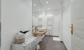 A modern bathroom with bright walls and a wooden vanity. It features a large mirror and pleasant lighting.