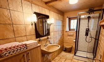 A modern bathroom with wooden paneling and tiles. There is a shower, a sink, and a large mirror.