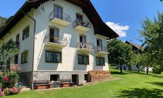 A beautiful house with balconies and a well-kept garden. The surroundings are green and inviting.