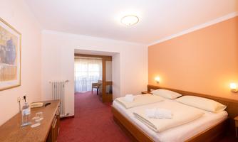 A cozy room with a double bed and a warm, inviting color tone. The room is bright and provides a pleasant atmosphere for relaxation.