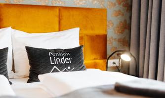 A cozy bedroom with an elegant yellow headboard and stylish pillows. The sunny colors and modern lighting create a welcoming atmosphere.