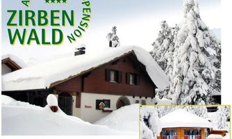 A charming, snow-covered house surrounded by tall, snow-covered fir trees. The image shows the apartment guesthouse Zirbenwald in a wintry landscape.