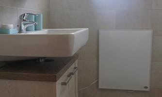 A modern bathroom with a sink and a large window. A light blue bath towel is on the floor.