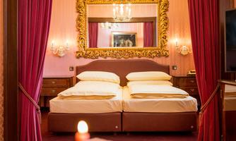 An elegant bedroom with a double bed and an antique mirror. The walls are in soft shades of pink and framed by red curtains.