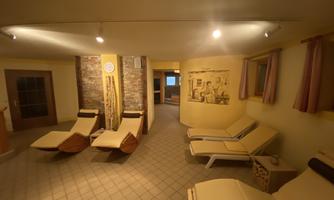 A relaxing quiet room with loungers and warm colors. The walls are decorated with decorative elements and a calming atmosphere.