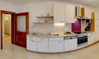 A modern kitchen with bright cabinets and stainless steel appliances. The space features tiled floors and windows that let in plenty of light.