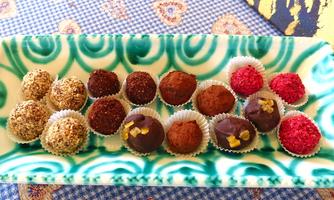 A stylish display of various chocolates in different colors and shapes. The chocolates are artistically decorated and offer a variety of flavors.
