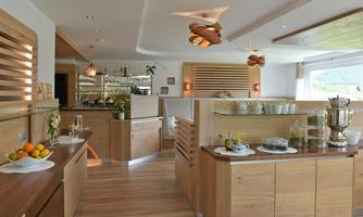 A modern kitchen with wood paneling and functional design. Fresh fruit and various drinks are on the counter.
