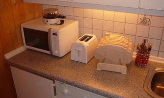 A modern kitchen with a microwave, a toaster, and a dish rack. The workspace is clean and well-organized.