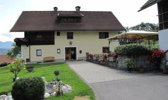 A charming house with a garden and a paved path. The surroundings are green and inviting.