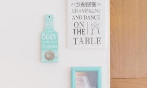 A wall decoration with various signs and pictures. The motifs celebrate social gatherings and drinks like beer and gin.