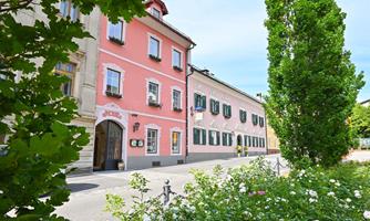A picturesque street with colorful houses and green trees. Flower beds give the surroundings an inviting character.