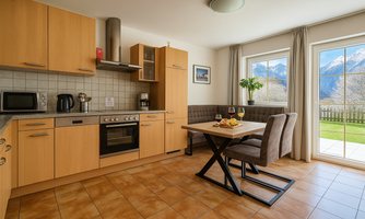 A modern kitchen with wood cabinets and a dining area. A beautiful mountain landscape can be seen through the window.