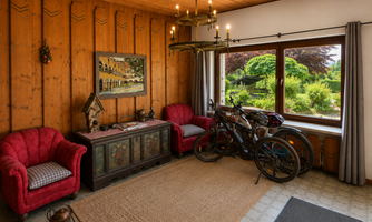 A cozy entrance area with armchairs. The entrance area becomes an e-bike parking space in the summer, and you can also charge your batteries there, with a view of the garden through the large window.