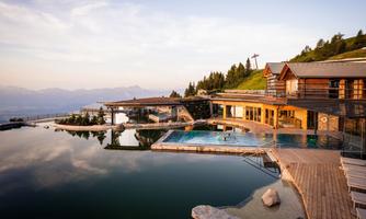 A modern wellness resort with an infinity pool and breathtaking mountain views. The architecture is harmoniously integrated into the natural surroundings.