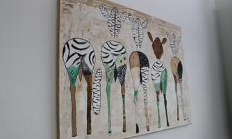 A work of art featuring stylized animals reminiscent of zebras and a giraffe. The colors are predominantly in black, white, and green.