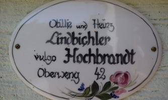 A decorative sign with the names Otilie and Heinz Lindbichler, commonly known as Hochbrandt. It displays the address Oberweng 42.