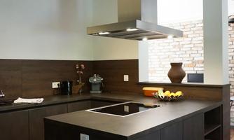 A modern kitchen with a kitchen island and a range hood. The color scheme is in dark wood tones and neutral colors.