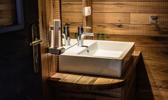 A modern sink in a wooden bathroom. The warm wooden paneling creates an inviting atmosphere.