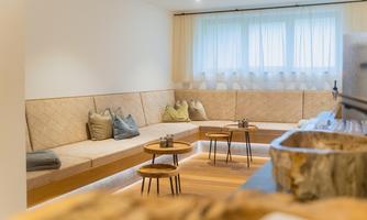 A modern room design with a cozy bench and a clear, bright ambiance. Small tables invite relaxation and lingering.