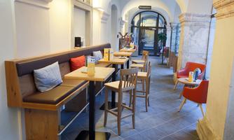 A cozy interior with a table and chairs. The walls are light, and there is an inviting passage.