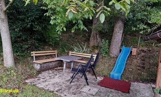 A cozy outdoor seating area with a table and chairs. Nearby, there is a slide for children.