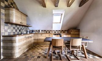 A modern kitchen with wooden furniture and a rustic design. The large dining table and chairs invite you to linger.