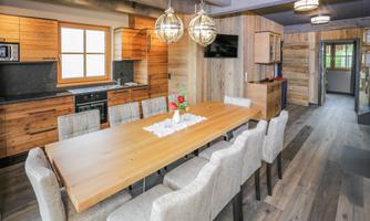 A modern kitchen with wood paneling and a large dining table. Bright, inviting rooms with a warm atmosphere.