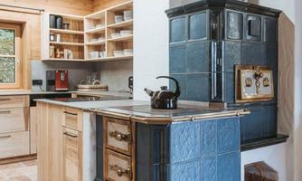 A modern kitchen with wood decor and elegant tiles. The nostalgic stove adds a rustic charm.