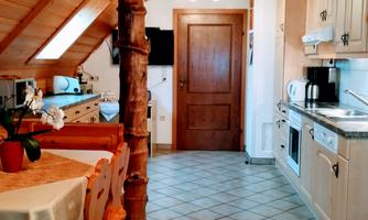 A bright, cozy kitchen with wood decor and modern appliances. The space is well-structured and offers an inviting dining area.