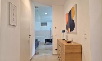 A bright hallway with a modern dresser and an abstract artwork on the wall. The room feels welcoming and friendly.