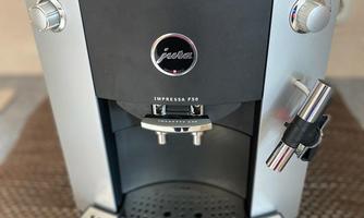An elegant coffee machine in silver design. It has a modern look and several controls.