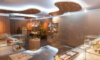 A stylish shop with elegant display cases showcasing various products. In the background stands a decorated Christmas tree.