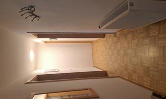 A bright hallway with wooden flooring. Mirrors and a coat rack are mounted on the walls.