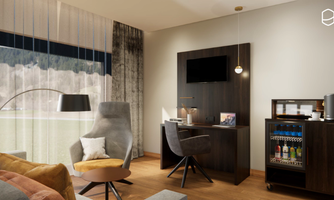 A modern room with comfortable furniture and large windows that provide plenty of natural light. A desk and a small bar with drinks complement the space.
