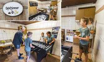 A(playroom with a foosball table and several people having fun. The walls are tiled and there are wooden shelves in the background.