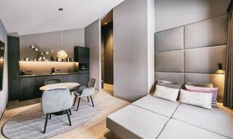 A modern room with a cozy sleeping area and a small dining space. The walls are in neutral colors, and the room feels bright and inviting.