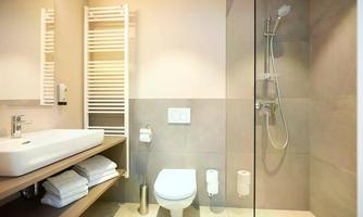 A modern bathroom with a shower and sink. The walls are painted in neutral tones and there are fresh towels.