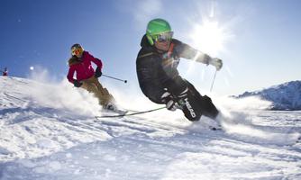 Two skiers on a sunny slope. The snow sparkles in the sunlight, creating perfect conditions.