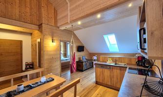 A cozy woodworking shop with a modern kitchen and a dining area. Large windows provide plenty of natural light.