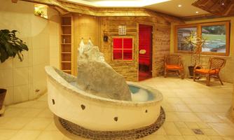 An inviting wellness area with a whirlpool and wooden details. The cozy atmosphere is complemented by plants and soft lighting.