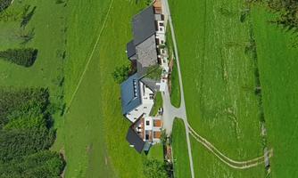 An idyllic landscape with several modern farmhouses. The fresh green lawn and gentle hills create a peaceful atmosphere.