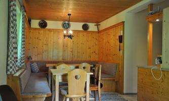 A cozy dining area with wooden furniture and a warm wood decor. The atmosphere is inviting and rustic.
