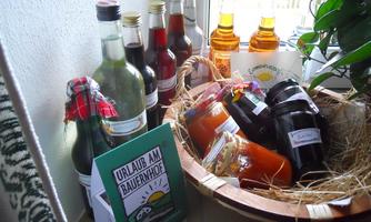 A selection of homemade drinks and jams in a cozy corner. In the foreground is an information sheet about a farm holiday.