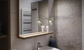 A modern bathroom with a sink and a large mirror. Flowers in a vase add a touch of elegance.