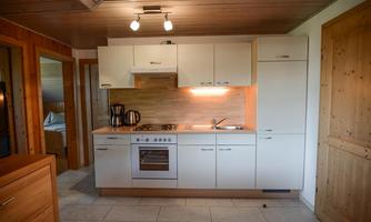 A modern kitchen with bright cabinets and stainless steel appliances. The space is well-lit and has an inviting, rustic charm.