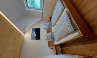 A cozy bedroom with a double bed and modern bedcovers.  
Large windows let in plenty of daylight and offer a view of the surroundings.